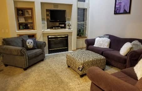 living room of a sober living house with flat screen TV and fireplace